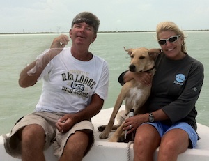 Bobby, Andrea and puppy Clark on the water.